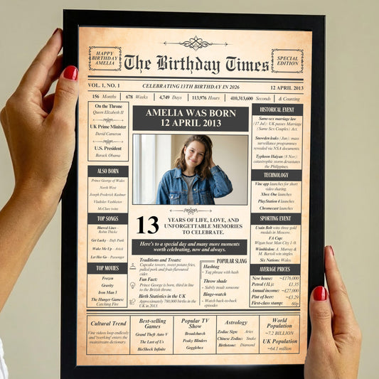 a person holding a framed newspaper-style birthday announcement for a young woman named Amelia. The announcement includes text and a photo of the individual, celebrating her 13th birthday.